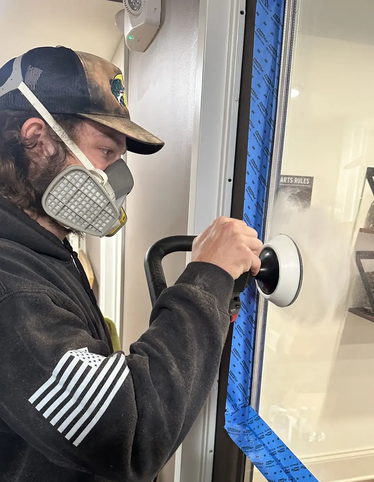 Technician polishing window glass and applying protective sealant